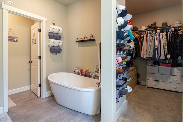 bathroom with a freestanding bath, baseboards, and wood finished floors