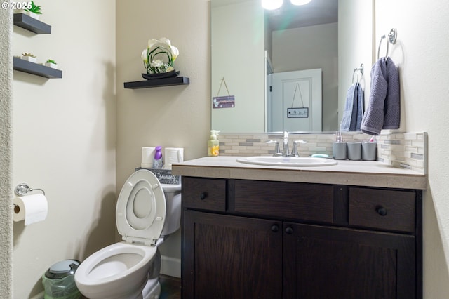 bathroom featuring toilet, tasteful backsplash, and vanity