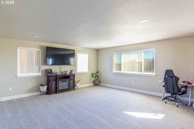 carpeted home office with a textured ceiling and baseboards