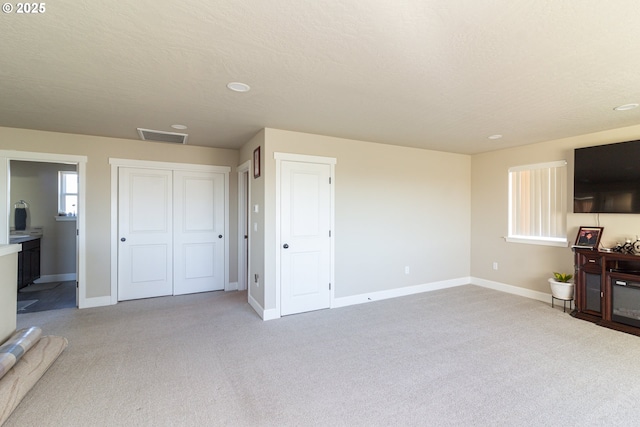 living area with carpet floors, visible vents, and baseboards