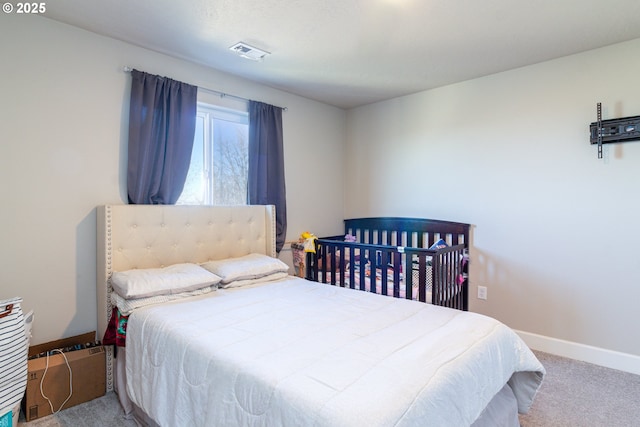 carpeted bedroom featuring visible vents and baseboards