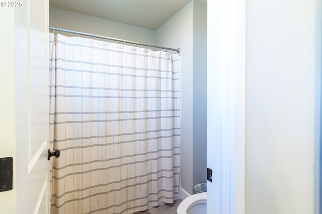 full bathroom featuring toilet and a shower with shower curtain