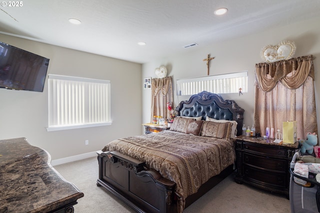 bedroom with carpet, multiple windows, visible vents, and baseboards