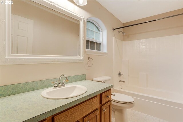 bathroom with toilet, vanity, tile patterned flooring, and washtub / shower combination