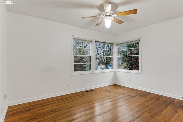 unfurnished room featuring visible vents, baseboards, and wood finished floors