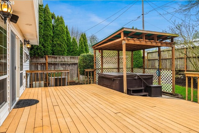 wooden deck with a fenced backyard and a hot tub