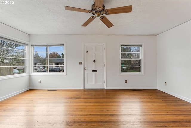 interior space featuring visible vents, a textured ceiling, and wood finished floors