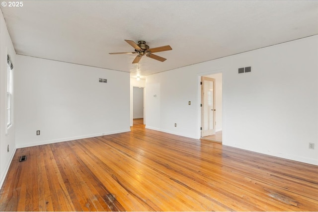 unfurnished room featuring light wood-style flooring, visible vents, and a ceiling fan