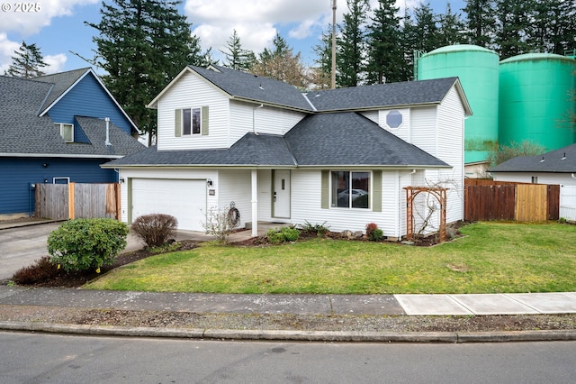 traditional-style home featuring a front lawn, concrete driveway, fence, and a shingled roof