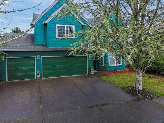 view of front of home featuring a shingled roof, a front yard, and driveway