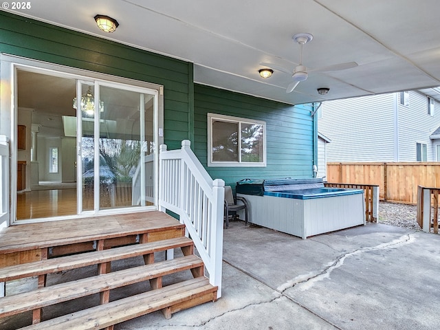 view of patio featuring ceiling fan, fence, and a hot tub