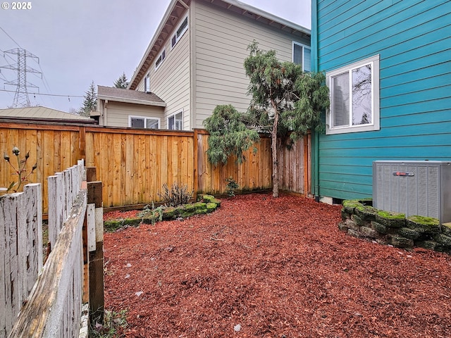 view of yard with fence and central air condition unit