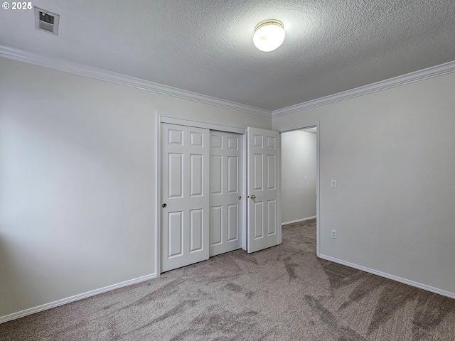 unfurnished bedroom featuring ornamental molding, baseboards, visible vents, and carpet flooring