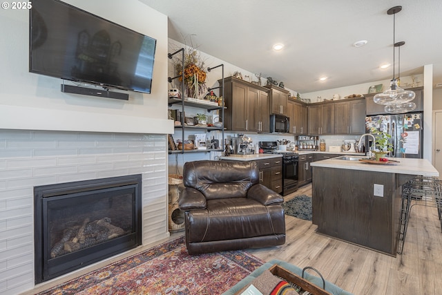 1850 NW Landon St, Mcminnville, OR 97128 - kitchen featuring black appliances, a sink, dark brown cabinets, light wood finished floors, and light countertops