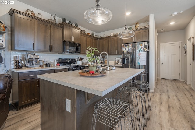 1850 NW Landon St, Mcminnville, OR 97128 - kitchen featuring black microwave, range, stainless steel fridge with ice dispenser, a kitchen bar, and light countertops