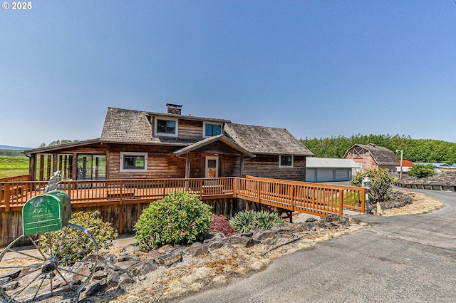 77993 Point Adams Rd, Clatskanie, OR 97016 - view of front facade with a wooden deck, a chimney, and log exterior