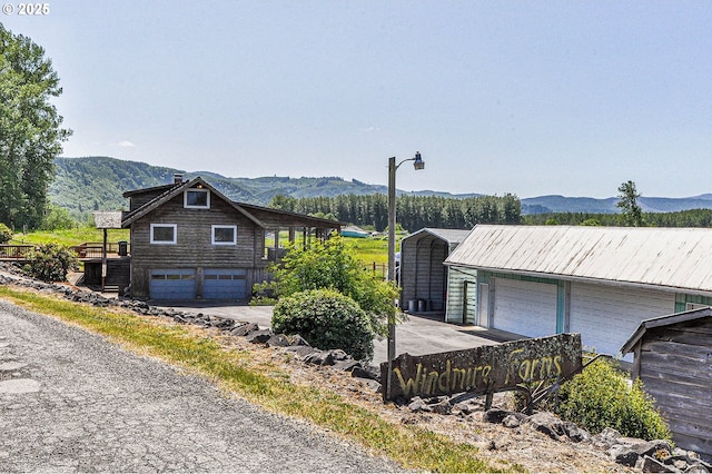 77993 Point Adams Rd, Clatskanie, OR 97016 - view of side of home with a mountain view, a detached carport, and a garage