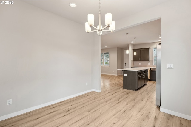 kitchen with a center island, light wood-style floors, dark brown cabinetry, light countertops, and baseboards