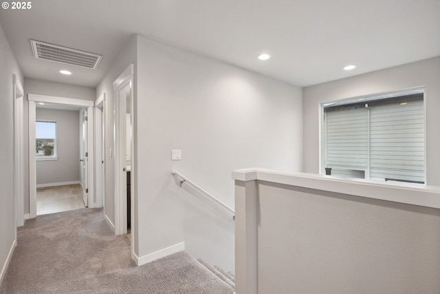 corridor with an upstairs landing, visible vents, recessed lighting, and carpet