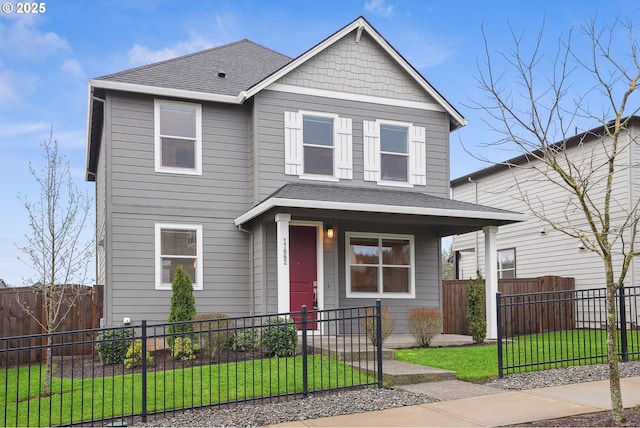 view of front of home featuring a front lawn, covered porch, a fenced front yard, and roof with shingles