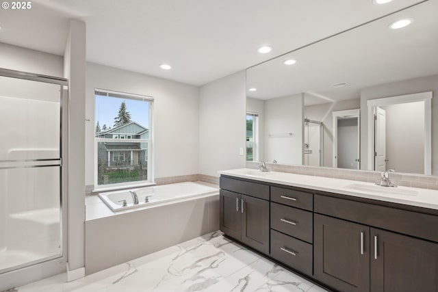 bathroom with recessed lighting, a stall shower, marble finish floor, and a sink