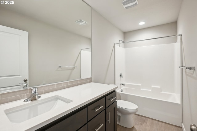 full bathroom with visible vents, toilet, wood finished floors, and vanity