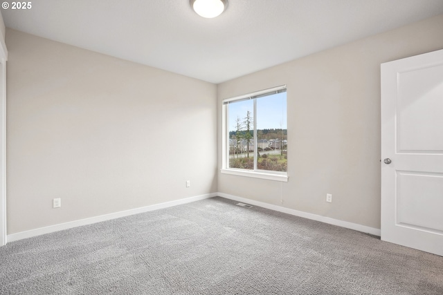 unfurnished room with visible vents, baseboards, and carpet floors