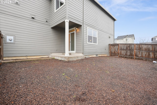 back of property with a gate, fence, and a patio area