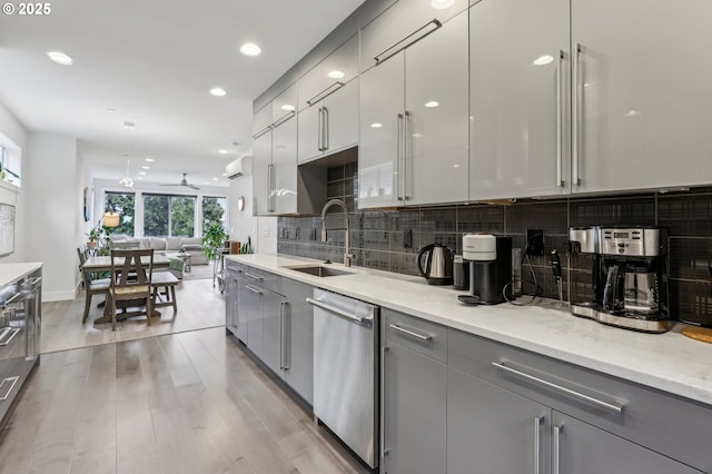 kitchen featuring stainless steel dishwasher, modern cabinets, a sink, and gray cabinetry