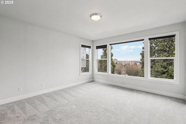 unfurnished room featuring carpet floors and baseboards