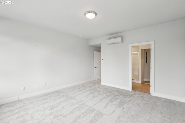 empty room with a wall unit AC, carpet flooring, and baseboards