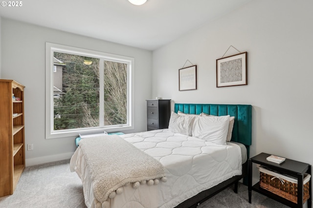 bedroom with light colored carpet and baseboards