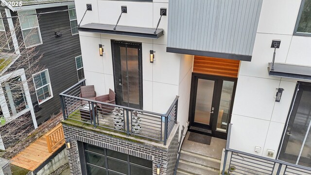 entrance to property featuring a balcony and stucco siding
