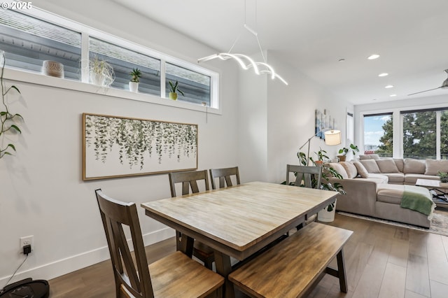 dining room with ceiling fan with notable chandelier, baseboards, wood finished floors, and recessed lighting