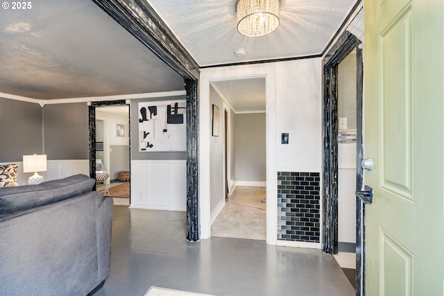 foyer entrance featuring ornamental molding, concrete floors, and a chandelier