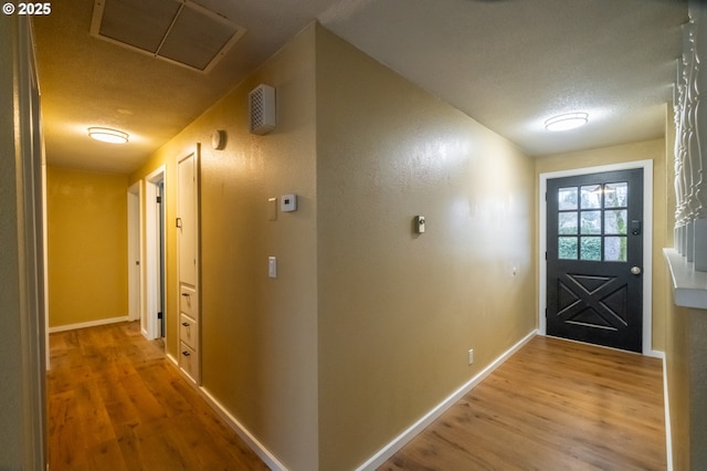 hall featuring wood-type flooring and a textured ceiling