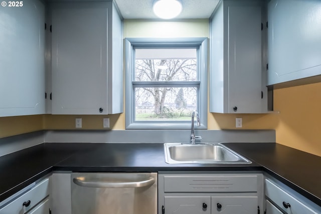 kitchen featuring stainless steel dishwasher, white cabinets, and sink