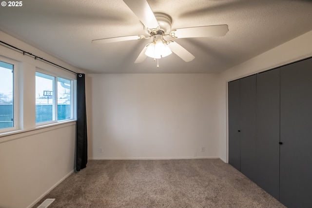 unfurnished bedroom featuring ceiling fan, a closet, and carpet flooring