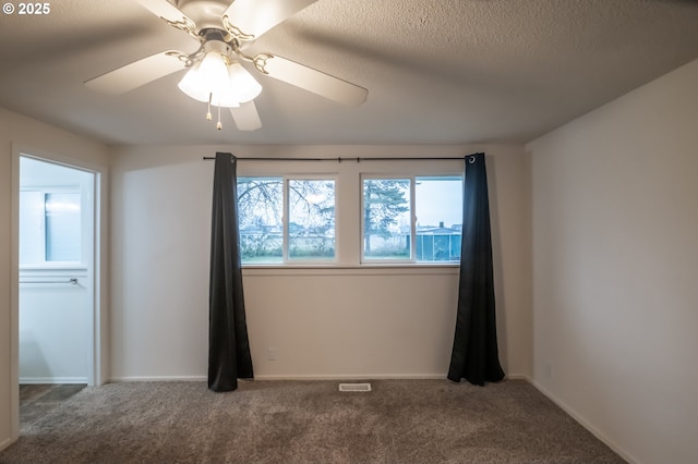 spare room featuring a textured ceiling, ceiling fan, and carpet flooring