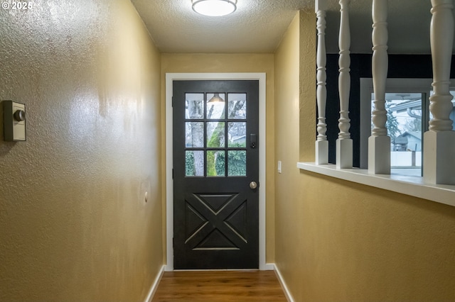 doorway to outside featuring a textured ceiling and hardwood / wood-style floors