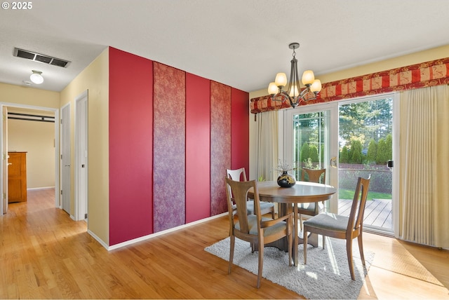 dining room featuring an inviting chandelier, light wood-style flooring, and visible vents