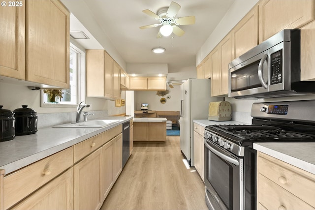 kitchen featuring stainless steel appliances, a ceiling fan, a sink, and light brown cabinets
