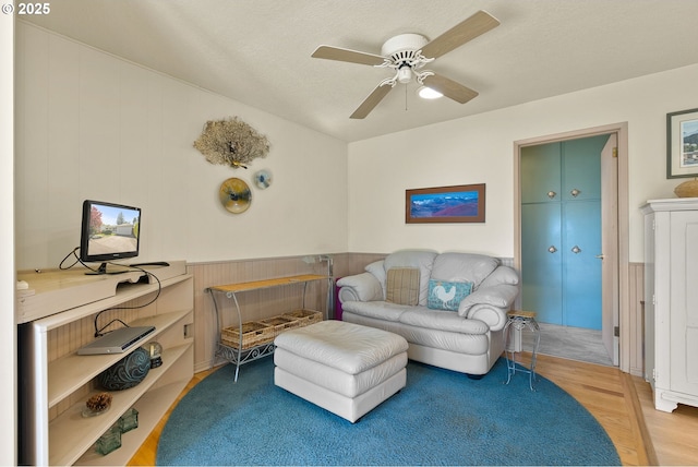 living area featuring a ceiling fan and wood finished floors