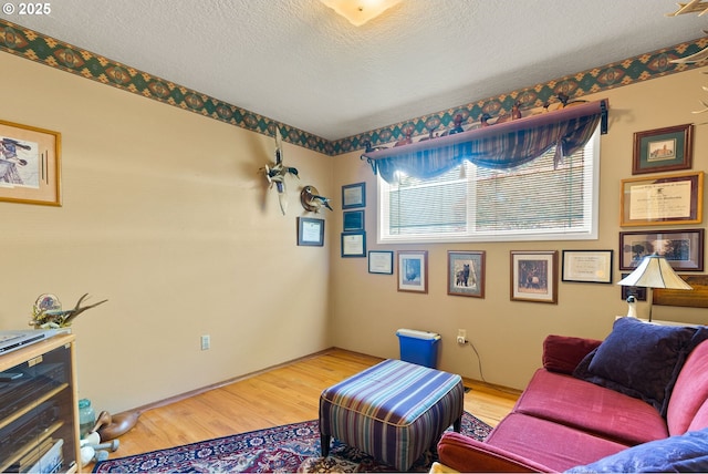 living area featuring light wood-style floors and a textured ceiling