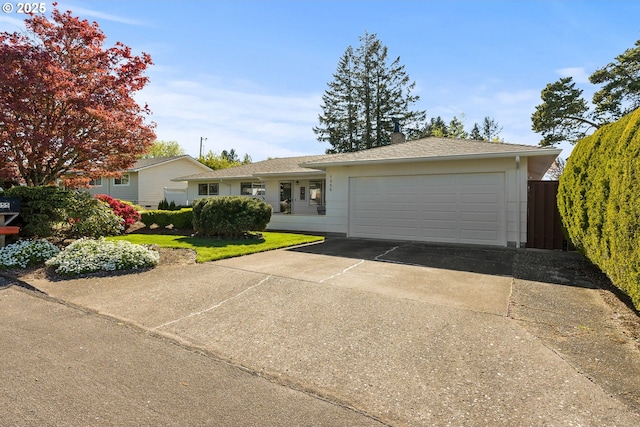 ranch-style house with an attached garage, fence, and driveway
