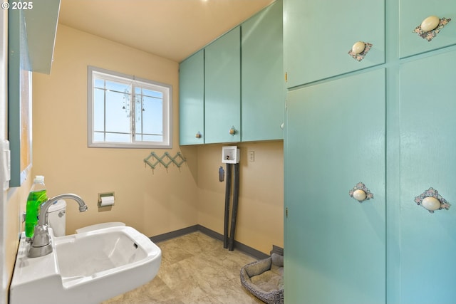 bathroom featuring a sink and baseboards