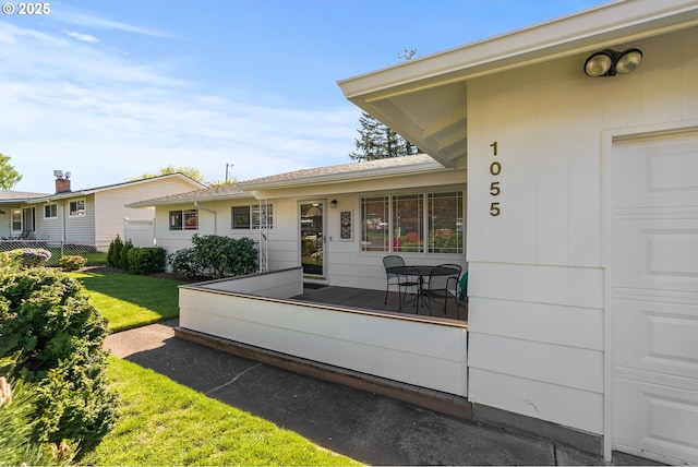 back of property featuring a lawn and fence