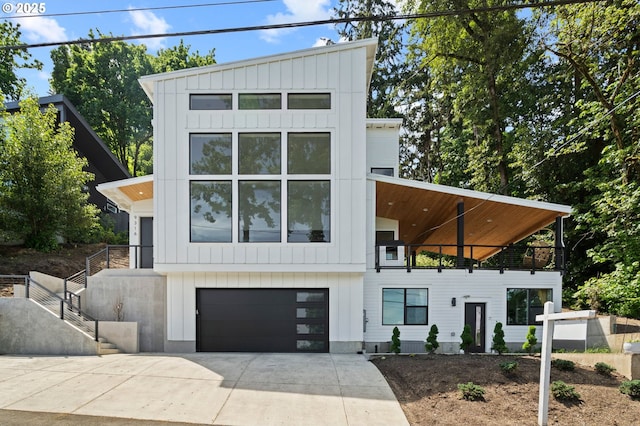 9316 NW Hardy Ave, Portland, OR 97231 - view of front facade with board and batten siding, driveway, a balcony, and a garage