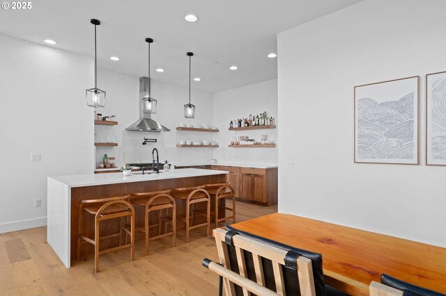 9316 NW Hardy Ave, Portland, OR 97231 - indoor wet bar with wall chimney range hood, light wood-style flooring, recessed lighting, pendant lighting, and baseboards