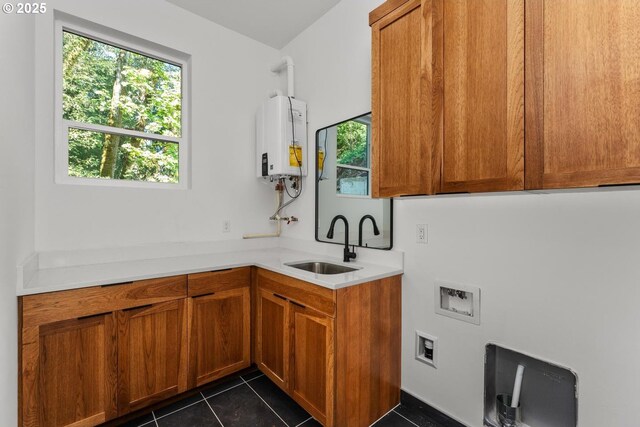 washroom featuring a sink, water heater, plenty of natural light, and washer hookup